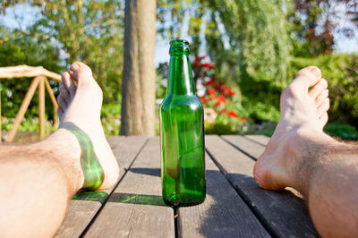 Low section of man with beer bottle on table