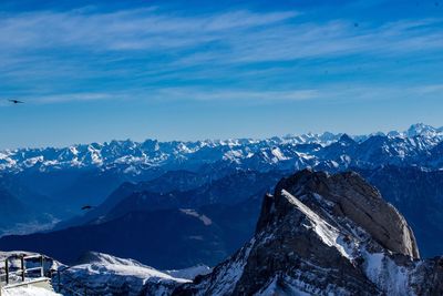 Scenic view of snowcapped mountains against blue sky