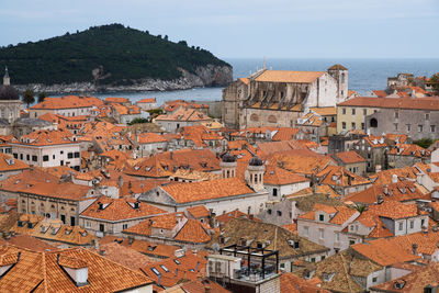 High angle view of rooftops against calm sea