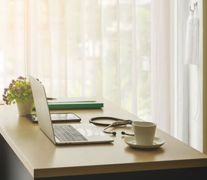 Coffee cup on table by window