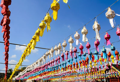 Low angle view of lanterns hanging against blue sky