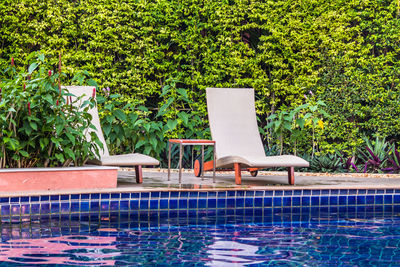 Chairs by swimming pool in yard