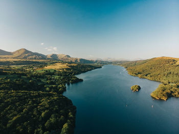 Panoramic view of sea and mountains against clear blue sky