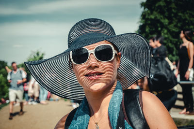 Portrait of young woman wearing sunglasses against sky