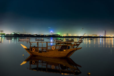 Boats moored in sea against sky at night