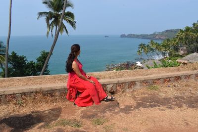 Woman standing by sea against sky