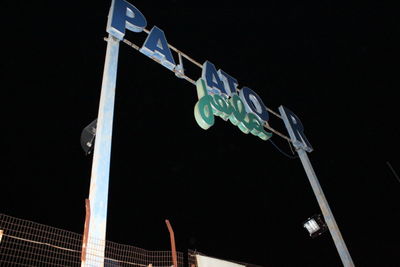 Low angle view of illuminated carousel against sky at night