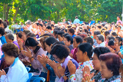 Crowd praying in temple against trees