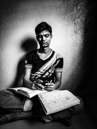 Mid adult man sitting against wall