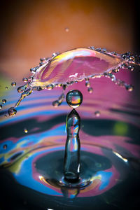 Close-up of raindrops splashing water