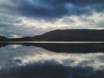 Scenic view of lake against sky at dusk