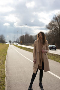 Woman standing on road against sky