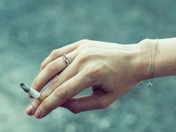 Close-up of hand holding cigarette