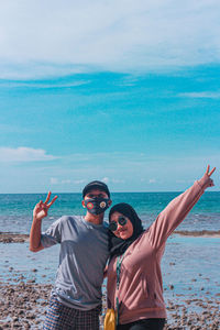 Portrait of young couple standing on beach