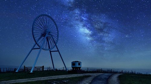 Apedale colliery wheel on field against starry sky