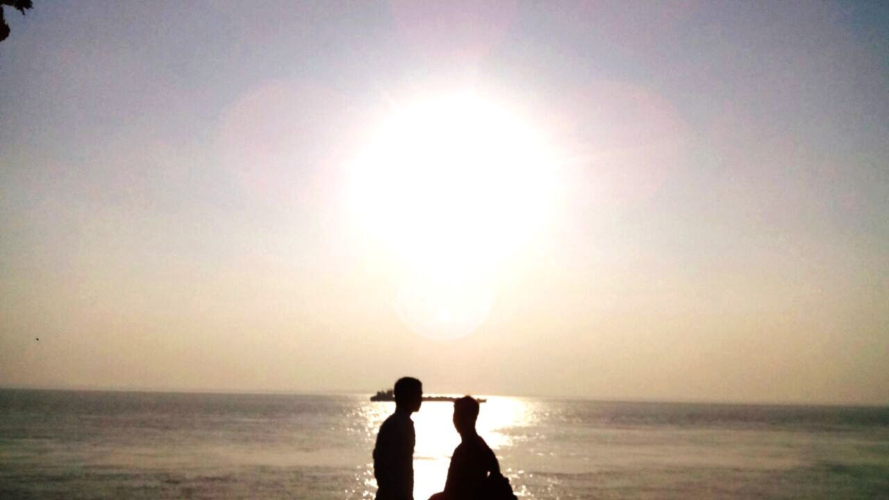 sky, sea, water, horizon, horizon over water, beach, nature, land, two people, beauty in nature, togetherness, silhouette, adult, sunlight, love, women, sunset, scenics - nature, men, leisure activity, bonding, sun, positive emotion, tranquility, lifestyles, emotion, standing, tranquil scene, outdoors, holiday, person, vacation, rear view, trip, three quarter length, idyllic, backlighting