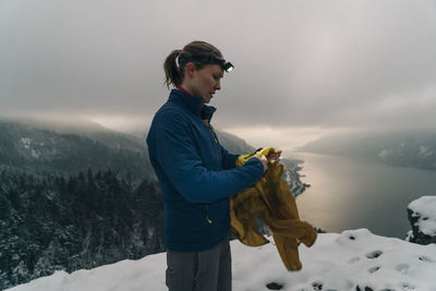 A young woman stands on the top of a snowy point in the columbia gorge