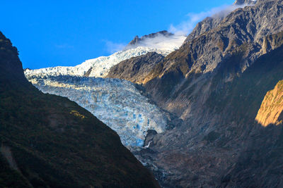 Scenic view of mountains against blue sky