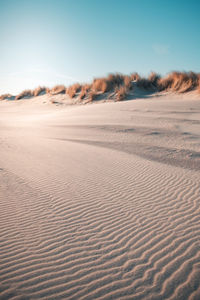 Sand dunes at desert against clear sky