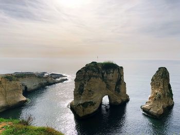 Rock formation in sea against sky