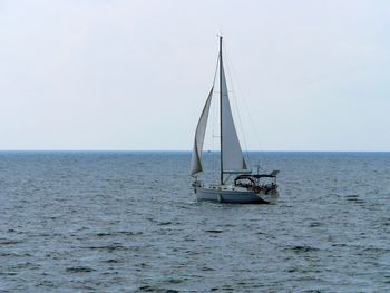 Boat sailing in sea against clear sky