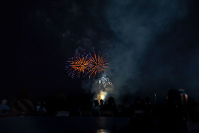 Low angle view of firework display at night