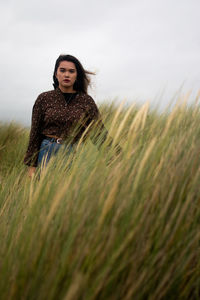 Portrait of a beautiful young woman on beach with reeds infront 