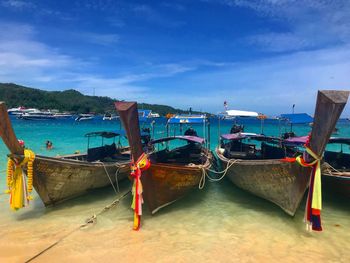 Boats moored on sea against blue sky