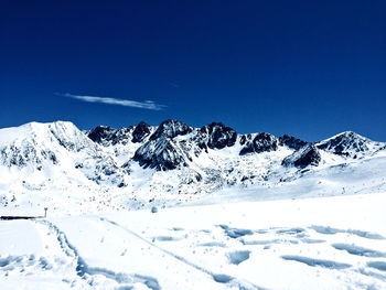 Scenic view of snowcapped mountains against clear blue sky