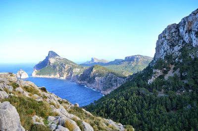 Panoramic view of sea and mountains against clear blue sky