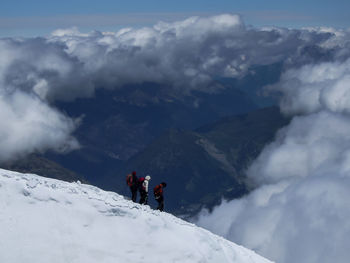 Tourists on snow covered mountain