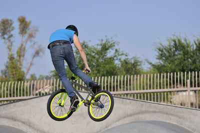 Man with bicycle on road against sky