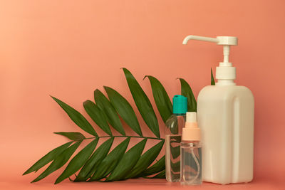 Close-up of green bottle on table against wall