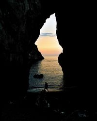 Silhouette of rock formations in sea