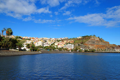 River with built structures against blue sky