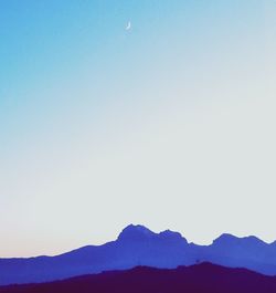 Scenic view of silhouette mountains against clear blue sky