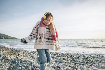 Girl with headphones and smart phone enjoying vacation at beach, gagra, abkhazia