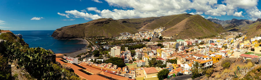 High angle view of townscape by sea against sky