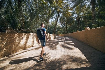 Man walking on footpath amidst trees