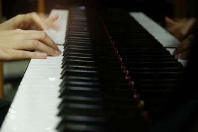 Cropped hands playing piano