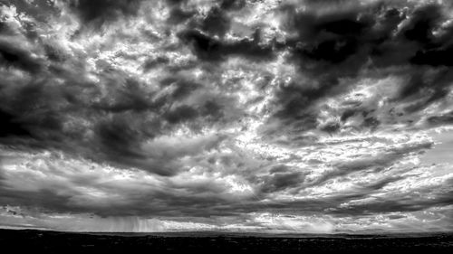 Low angle view of storm clouds over landscape