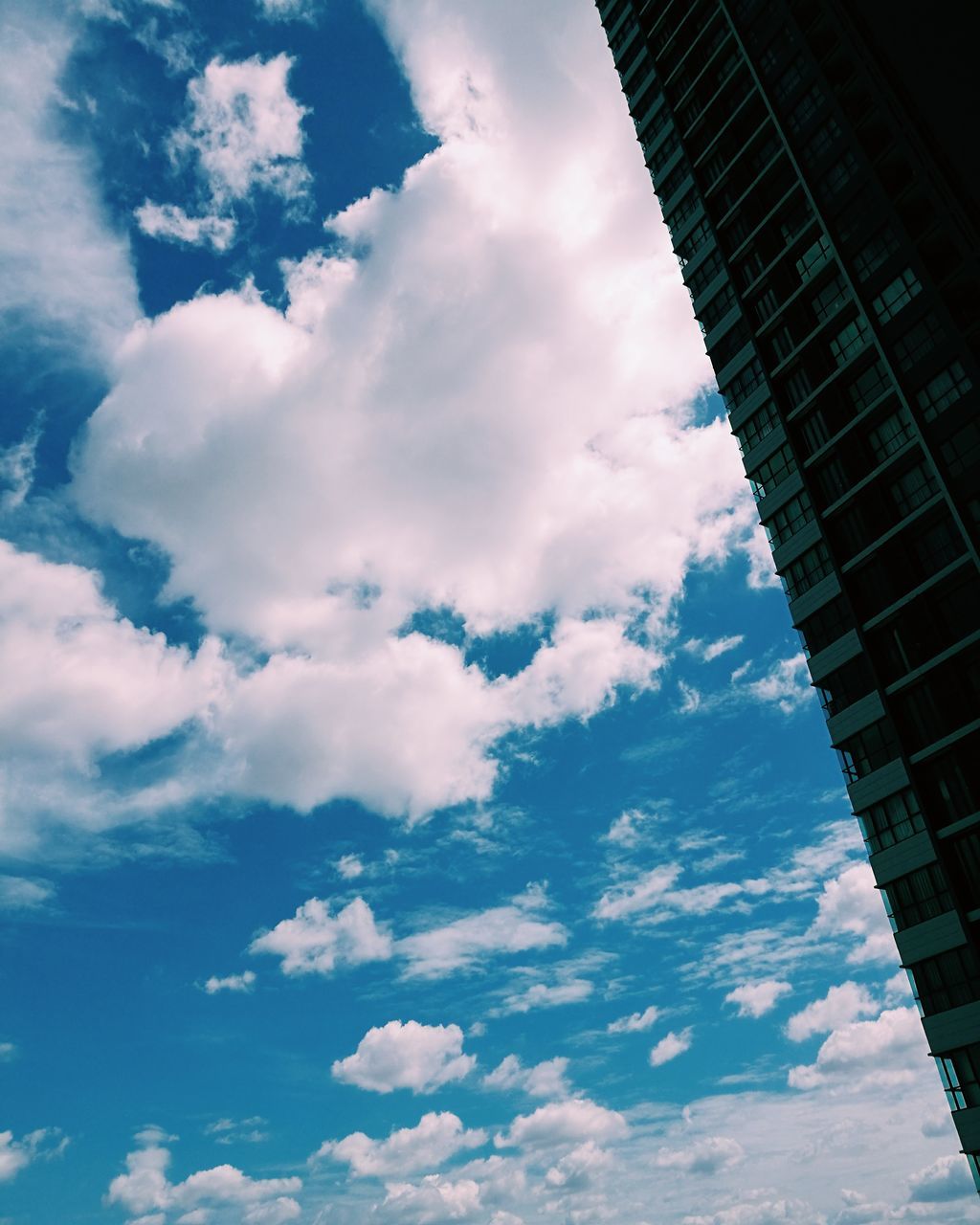 low angle view, sky, architecture, built structure, building exterior, cloud - sky, cloud, cloudy, building, tall - high, modern, city, day, outdoors, directly below, office building, tower, no people, blue, nature