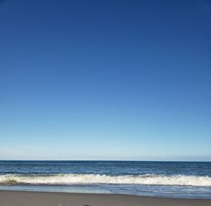 Scenic view of sea against clear blue sky