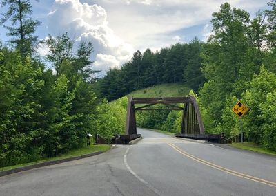 Road amidst trees against sky