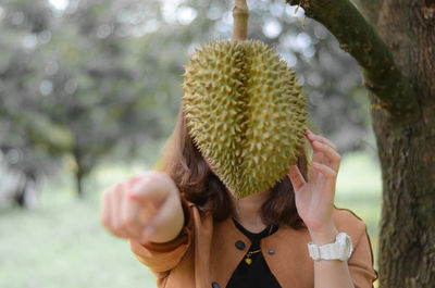 Woman behind hanging fruit at park