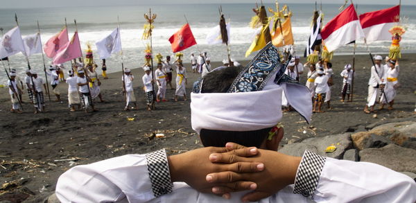 Another child watches the melasti ceremony on the seseh beach, bali, indonesia