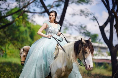 Portrait of woman riding horse on field