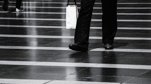 Low section of people standing on tiled floor