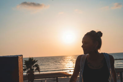 Woman standing at beach against sky