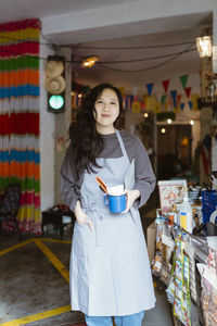 Smiling restaurant owner with hand in apron pocket